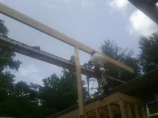 Carpenter setting a ridge beam over a new addition frame — Ice Dam Removal by Roofing Brothers in Glen Ellyn