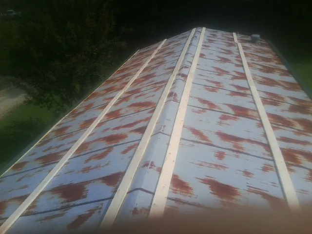 Rusted metal roof panels with new wood purlins before replacement — Storm Damage Roof Repair in Glen Ellyn by Roofing Brothers
