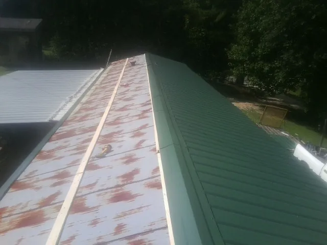 Old rusted panels beside newly installed green metal roofing — Wind Damage Roof Repair by Roofing Brothers in Glen Ellyn